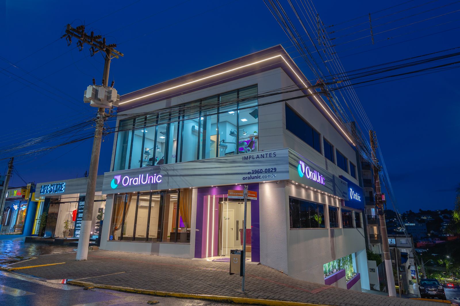Fachada iluminada da Oral Unic Caçador na R. 7 de Setembro, no Centro